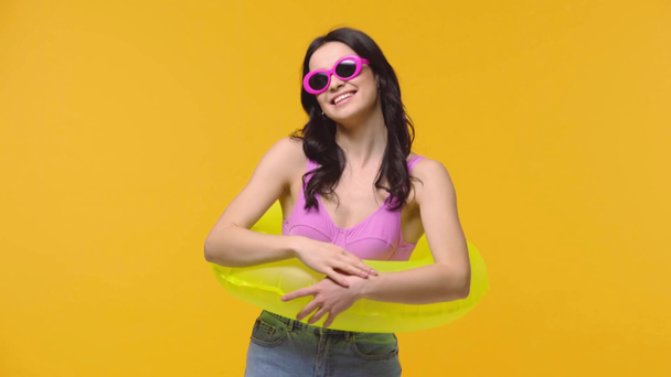 Happy woman with inflatable ring isolated on yellow  - Video