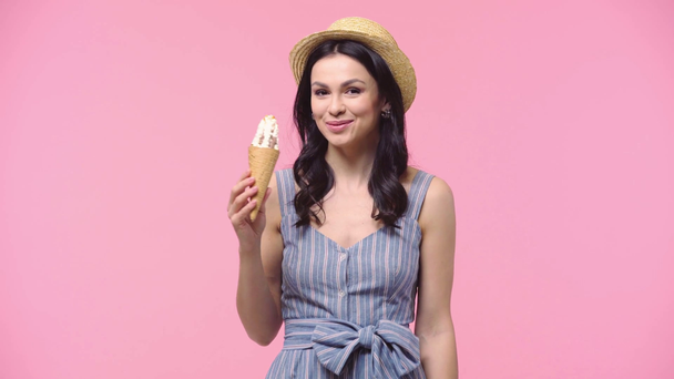 Vrouw glimlachen en het eten van ijs geïsoleerd op roze - Video