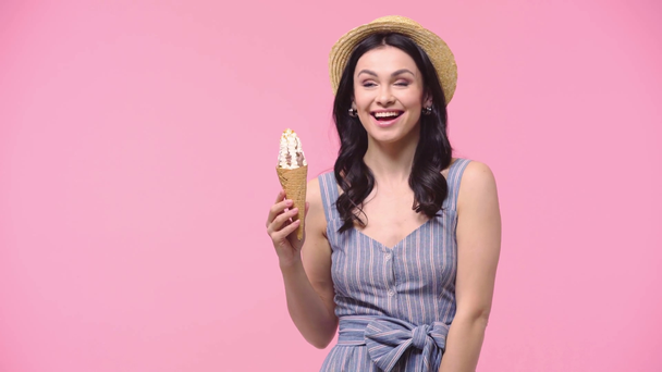 Nő mutatja fagylalt és mosolygós elszigetelt rózsaszín - Felvétel, videó