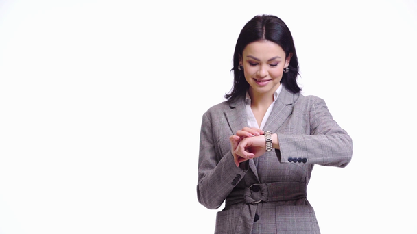 Geschäftsfrau schaut auf Armbanduhr und lächelt isoliert auf weißem Grund - Filmmaterial, Video