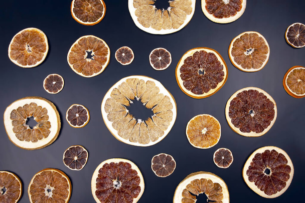Suszone plastry różnych owoców cytrusowych zbliżenie na ciemnym tle - Zdjęcie, obraz