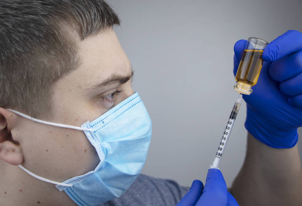 Doktor şırıngaya iğne yapıyor. Bir erkek doktor bir hastaya aşı enjekte etmek üzere. Nüfusun aşılanması ve aşılanması kavramı - Fotoğraf, Görsel