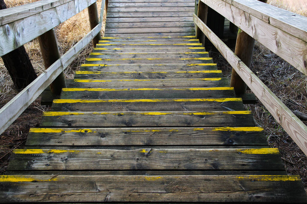 Old wooden stairway that go down. Going down stairs during outdoor walking. Aged wooden boards at a hiking trail.  - Photo, Image
