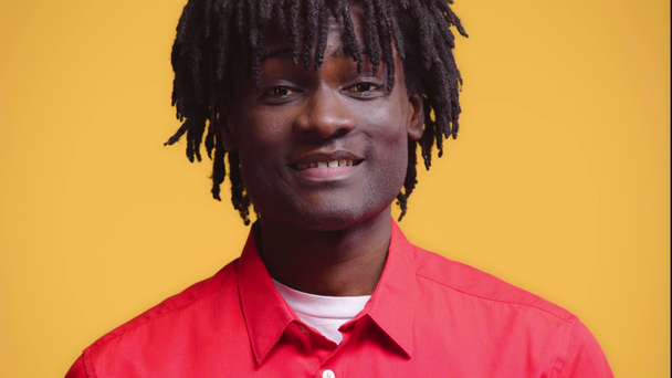 Πορτρέτο του Αφροαμερικανού άνδρα χαμογελώντας απομονωμένο στο κίτρινο - Πλάνα, βίντεο