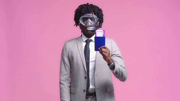 Afrikaans-Amerikaanse zakenman in duikmasker met vliegticket geïsoleerd op roze - Video