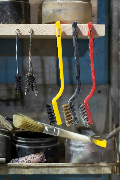 Varios cepillo de cable de metal en el espacio de trabajo de carpintero. Herramientas para limpiar metal
. - Foto, Imagen