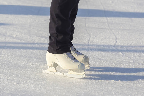 ноги на коньках человека, катающегося на катке - Фото, изображение