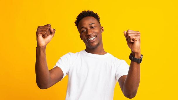 Fiatal, vidám afrikai srác, aki sárgán táncol - Fotó, kép