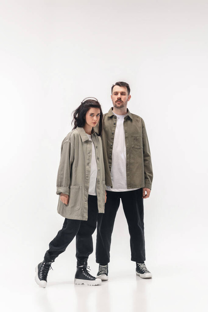 Trendy fashionable couple isolated on white studio background - 写真・画像