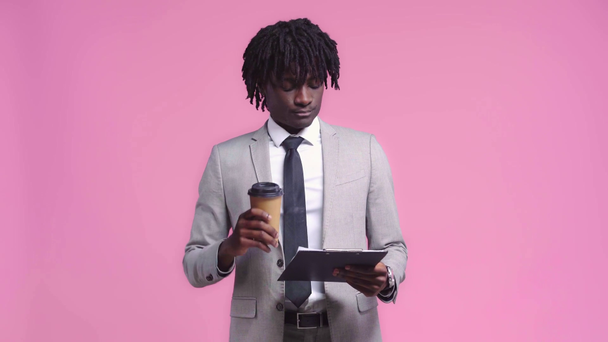 Uomo d'affari afroamericano con contratto bere caffè isolato su rosa
 - Filmati, video