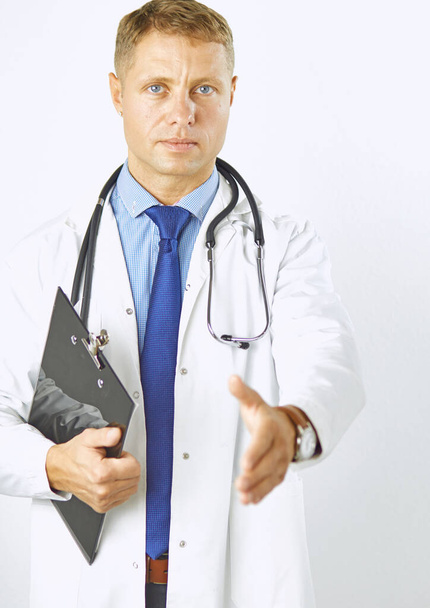 Mladý doktor v bílém plášti se stetoskopem mu podá ruku. - Fotografie, Obrázek