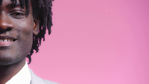 Vista parcial del empresario afroamericano sonriendo aislado en rosa
 - Imágenes, Vídeo