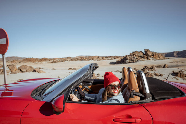 Woman traveling by cabriolet car on the desert velley - Fotó, kép