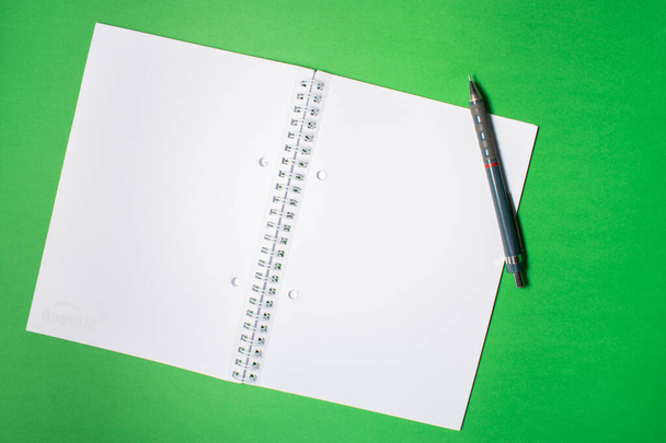 Vista superior de un cuaderno con un bolígrafo sobre un fondo colorido. Piso con espacio de escritura
 - Foto, imagen