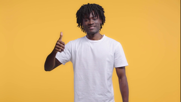 Hombre afroamericano con pulgar hacia arriba aislado en amarillo
 - Metraje, vídeo