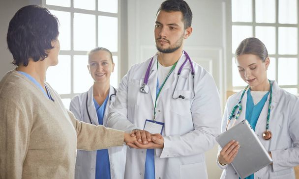 pacient se skupinou lékařů na pozadí - Fotografie, Obrázek