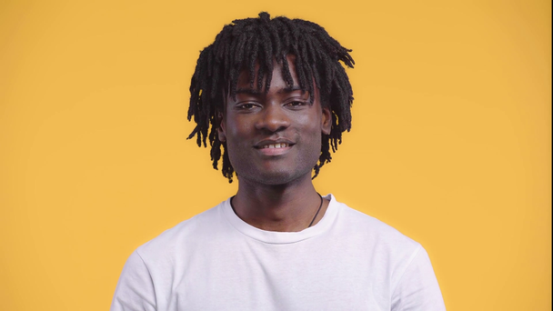 Retrato del hombre afroamericano sonriendo aislado en amarillo
 - Imágenes, Vídeo