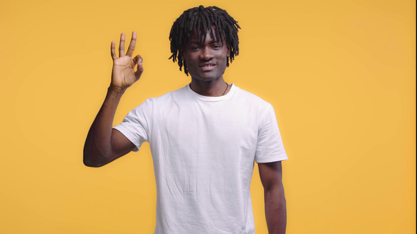 Afroamerikaner zeigt Okay-Zeichen auf gelb - Filmmaterial, Video