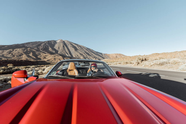 Vrouw reist per cabriolet auto op de vulkanische vallei - Foto, afbeelding