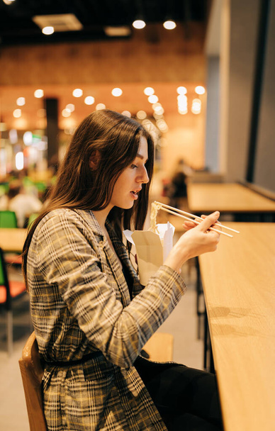 箸で中華料理を食べている若い女性の肖像画 - 写真・画像