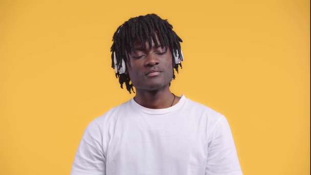Portret van Afro-Amerikaanse man met koptelefoon geïsoleerd op geel - Video