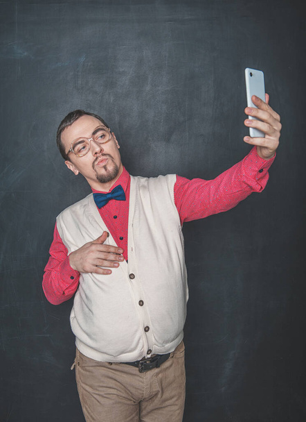 Ritratto di simpatico nerd uomo fare selfie su sfondo lavagna
 - Foto, immagini