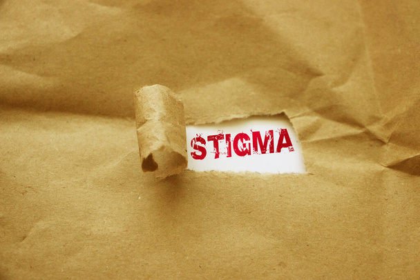 Palavra estigma em letras vermelhas mensagem escrita sob papel pacote marrom rasgado. - Foto, Imagem