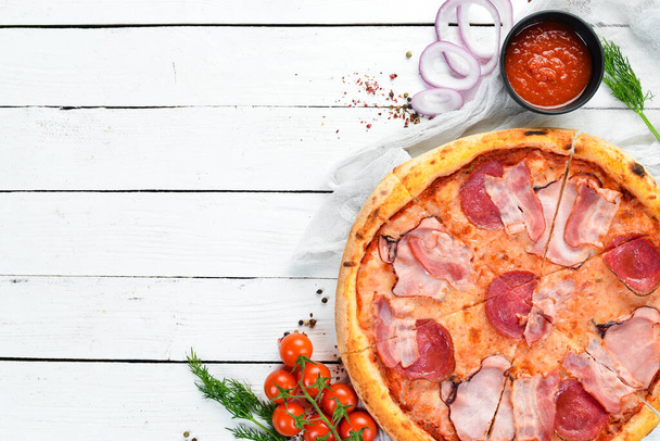 Pizza with salami and bacon on the old table. Italian snacks. Top view. Free space for your text. - 写真・画像
