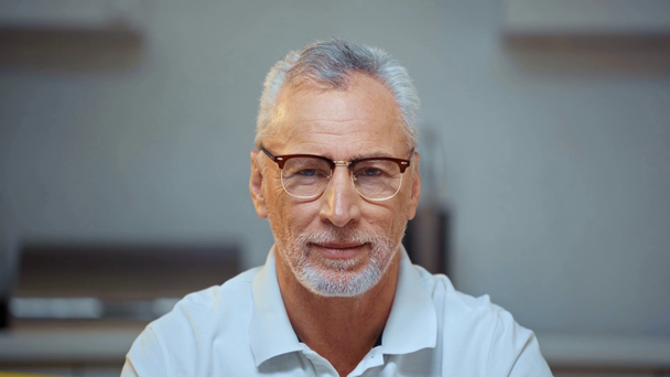 Hombre mayor en gafas mirando a la cámara
  - Imágenes, Vídeo