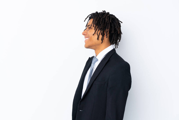 Junger afroamerikanischer Geschäftsmann vor isoliertem weißen Hintergrund, der zur Seite schaut - Foto, Bild