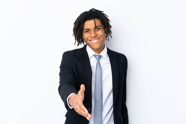 Junger afroamerikanischer Geschäftsmann über isolierten weißen Hintergrund beim Händeschütteln nach einem guten Geschäft - Foto, Bild
