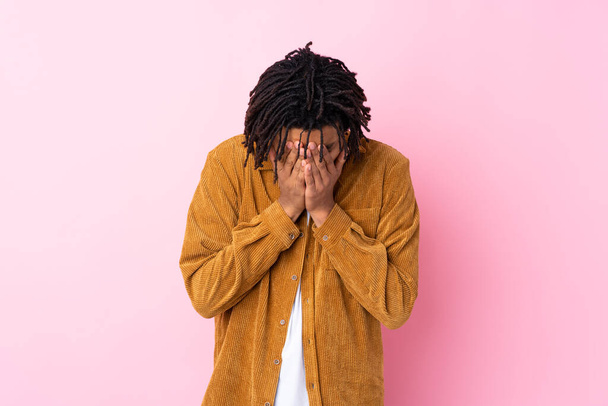 Молодий афроамериканець з корисливим піджаком над ізольованим рожевим фоном з втомленим і хворим виразом обличчя. - Фото, зображення