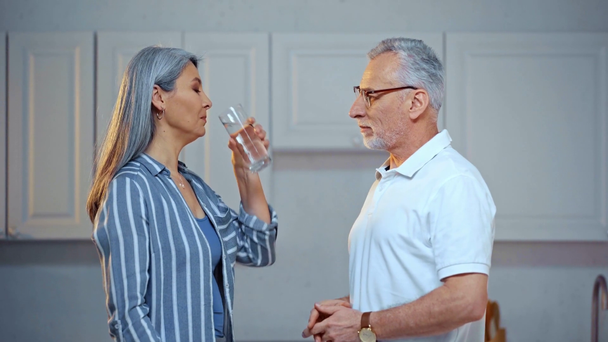 アジアの病気の妻に水をあげている老人は  - 映像、動画