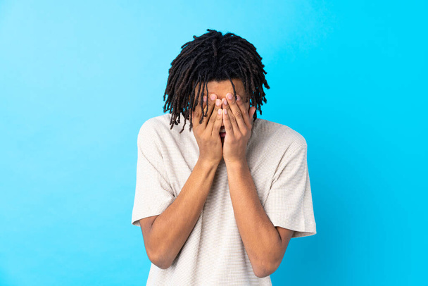 Fiatal afro-amerikai férfi elszigetelt kék háttér fáradt és beteg kifejezés - Fotó, kép