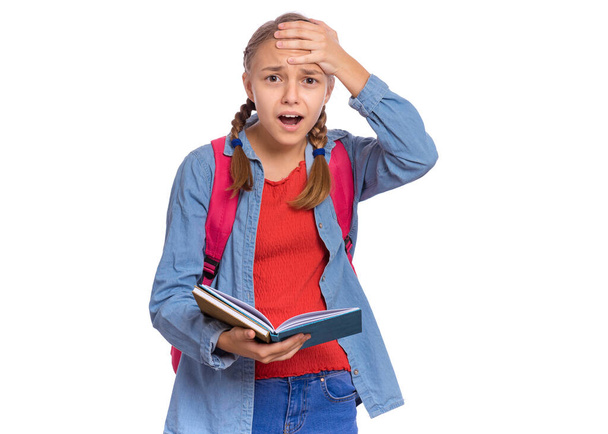 Portrait of surprised student teen girl with backpack, reading book in amazement. Shocked child with bag and open book Back to school. Girl opening eyes and mouth with shock, touching head with hand. - Photo, Image