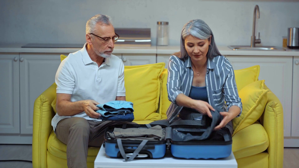 asiatico donna imballaggio valigia con felice anziano marito
  - Filmati, video