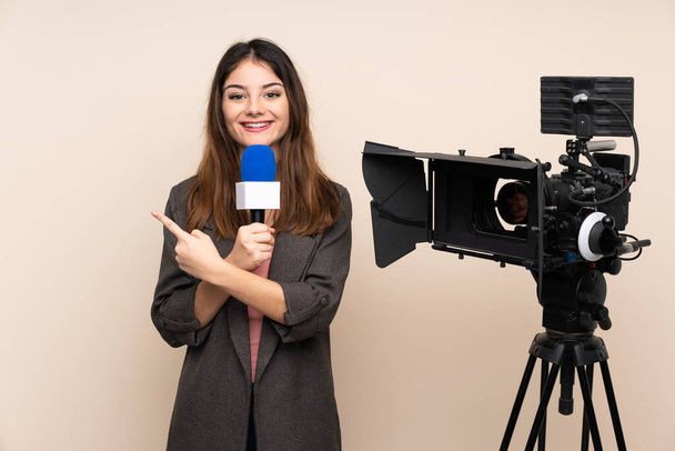 Жінка-репортер тримає мікрофон і повідомляє новини над ізольованим фоном, вказуючи пальцем на бік
 - Фото, зображення