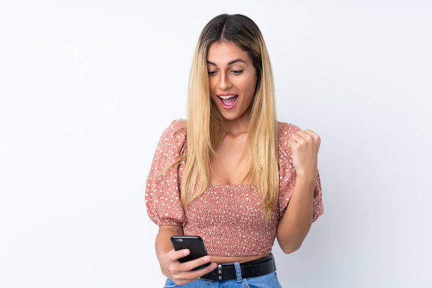 Young Uruguayan woman over isolated white background surprised and sending a message - Zdjęcie, obraz