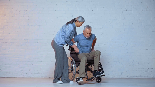 İlgili Asyalı kadın yaşlı kocaya tekerlekli sandalyede yardım ediyor.  - Video, Çekim