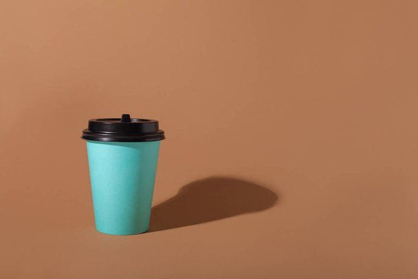 Brown background with one paper blue cup. Trend hard shadow. - Foto, immagini