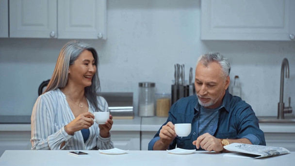 счастливая пожилая и межрасовая пара пьет кофе
  - Кадры, видео