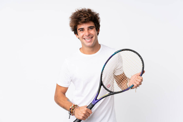 Young caucasian man over isolated white background playing tennis - Фото, изображение