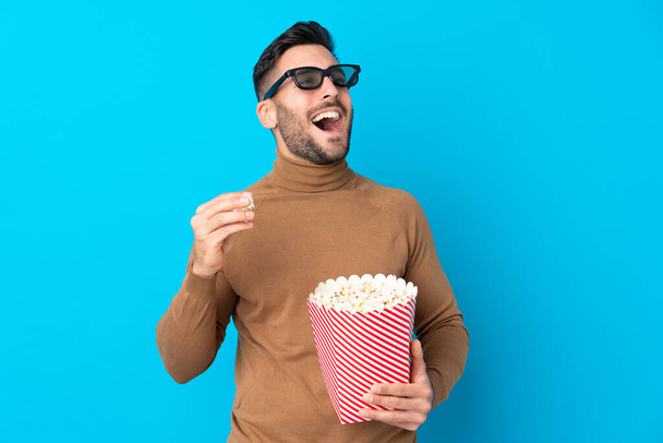 Giovane bell'uomo con occhiali 3d e in possesso di un grande secchio di popcorn
 - Foto, immagini