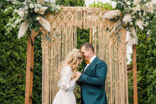 beautiful boho style wedding ceremony. The bride in a beautiful dress and the groom in a classic suit - Valokuva, kuva