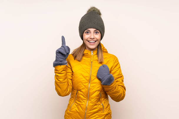 Femme avec chapeau d'hiver sur fond isolé avec expression faciale surprise - Photo, image