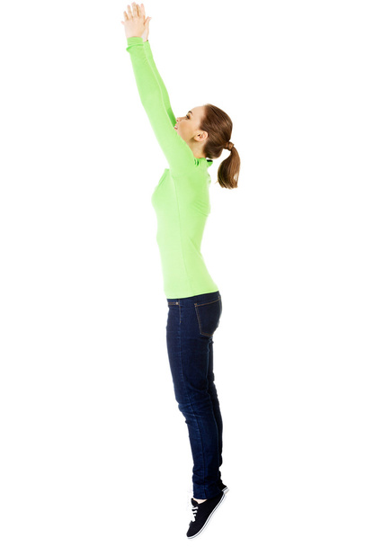 Attractive young woman jumping. Side view. - Photo, image