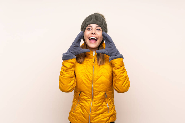 Женщина в зимней шляпе на изолированном фоне кричит с открытым ртом
 - Фото, изображение