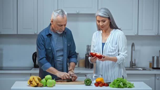 senior interracial couple cutting vegetables  - Footage, Video