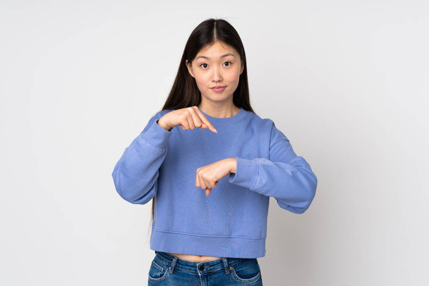 Young asian woman isolated on background making the gesture of being late - Foto, Imagen