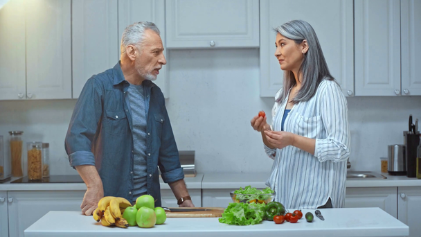 senior e interracial pareja hablando en cocina
  - Imágenes, Vídeo